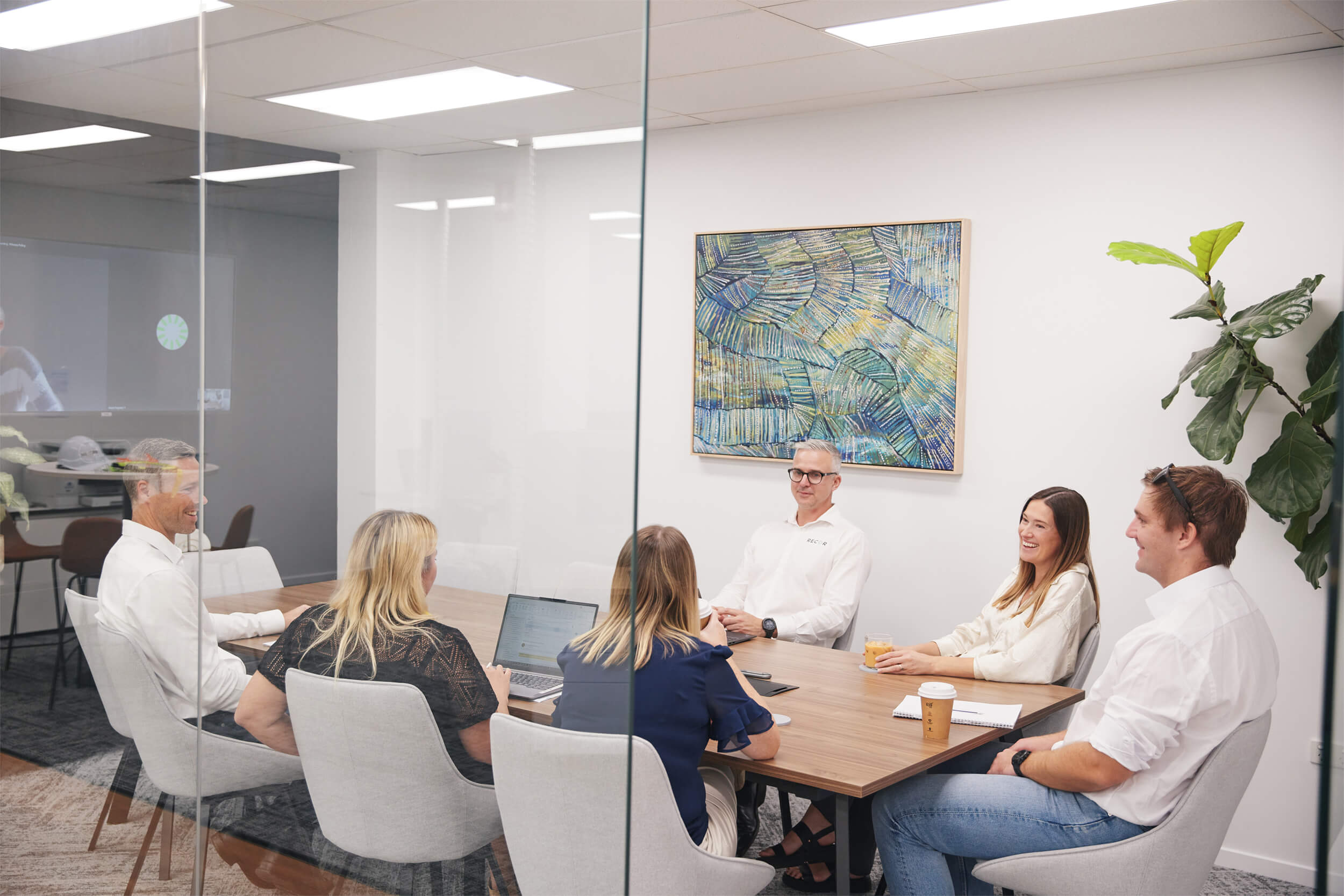 RECOR team members meeting around a boardroom table in a modern office
